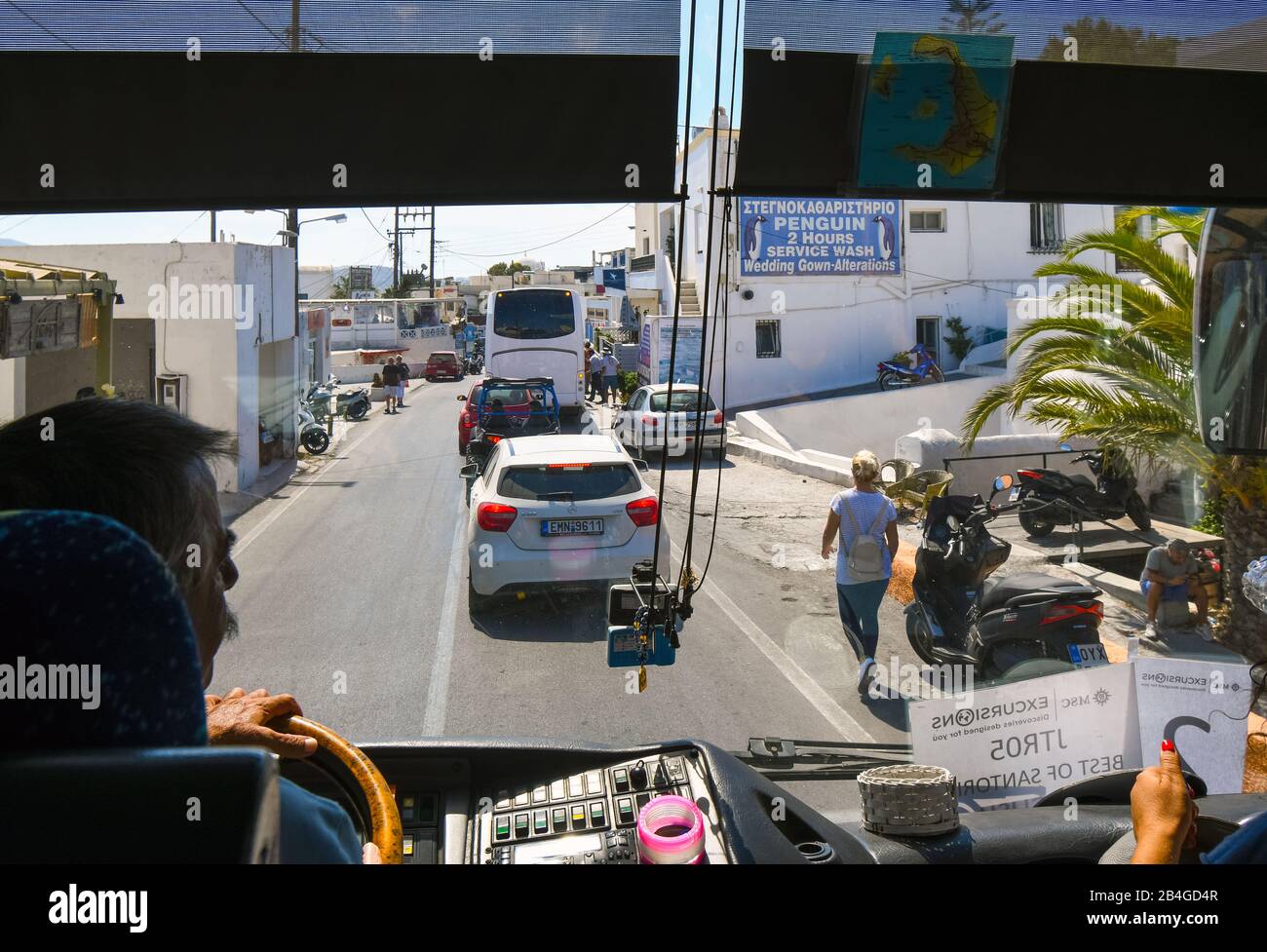 Vista dall'interno di un autobus turistico della stretta e affollata strada di negozi e aziende a Fira, conosciuta anche come Thira Grecia, sull'isola di Santorini Foto Stock