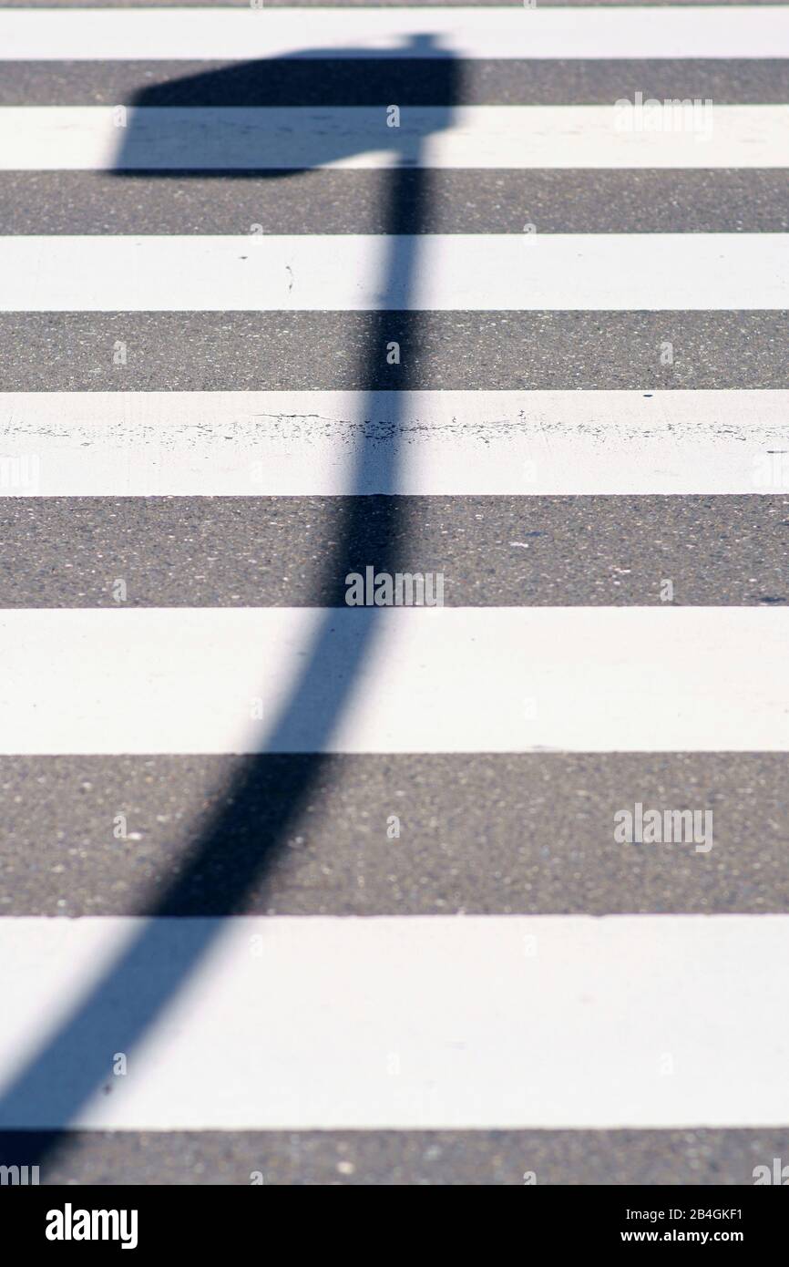 Un impressionante e lanterna ombra sul crosswalk di un attraversamento pedonale. Foto Stock