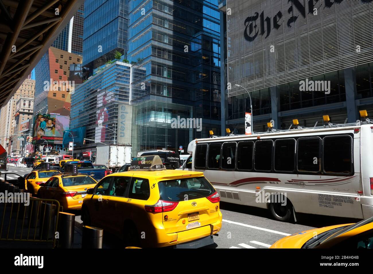 Taxi gialli in attesa di passeggeri al terminal degli autobus di Port Authority con la New York Times Tower progettata dall'architetto Renzo piano in background. 8th Avenue, New York, Stati Uniti Foto Stock