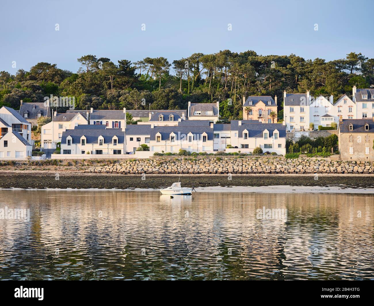Eigenheime während der goldenen Stunde an der Hafeneinfahrt zum Bootshafen in Audierne in der Bretagne Foto Stock