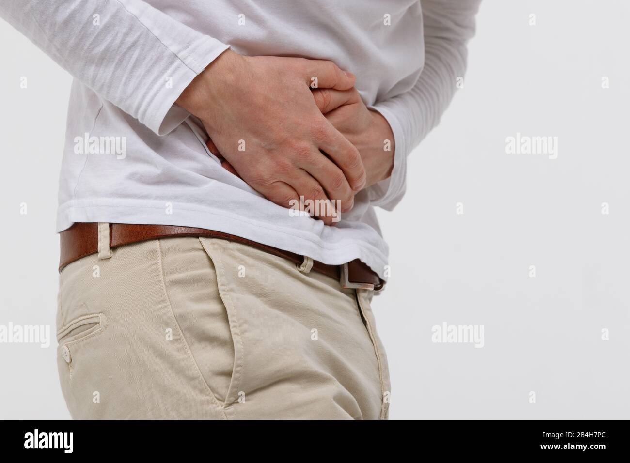 Studio ritratto di uomo che ha uno stomachache dopo aver mangiato cibi grassi malsani, crampi, isolato su sfondo bianco. Gastrite cronica, dolore alla pancia. Foto Stock