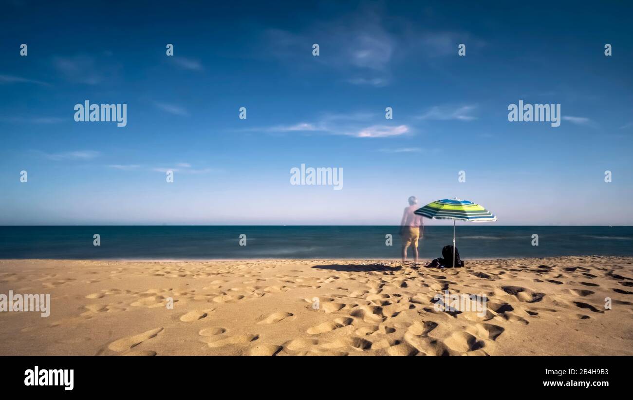 Einsamer Sonnenschirm und Person am Meer bei Saint Pierre la Mer Foto Stock