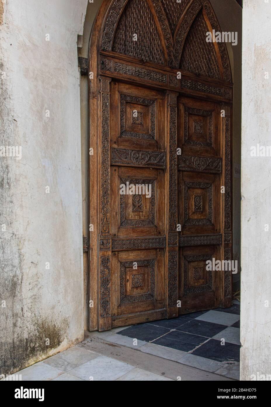 Tanzania, Isola di Zanzibar: Chiesa anglicana in Stone Town, costruita sul sito del vecchio mercato degli schiavi, come memoriale contro il commercio degli schiavi. Porta di legno, ingresso alla chiesa. Foto Stock