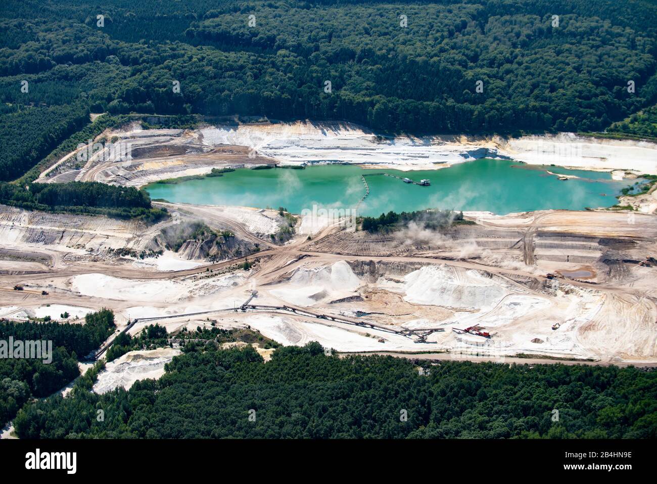 Veduta aerea di una pianta di quarzo circondata da foresta con un lago, degradazione della sabbia Foto Stock