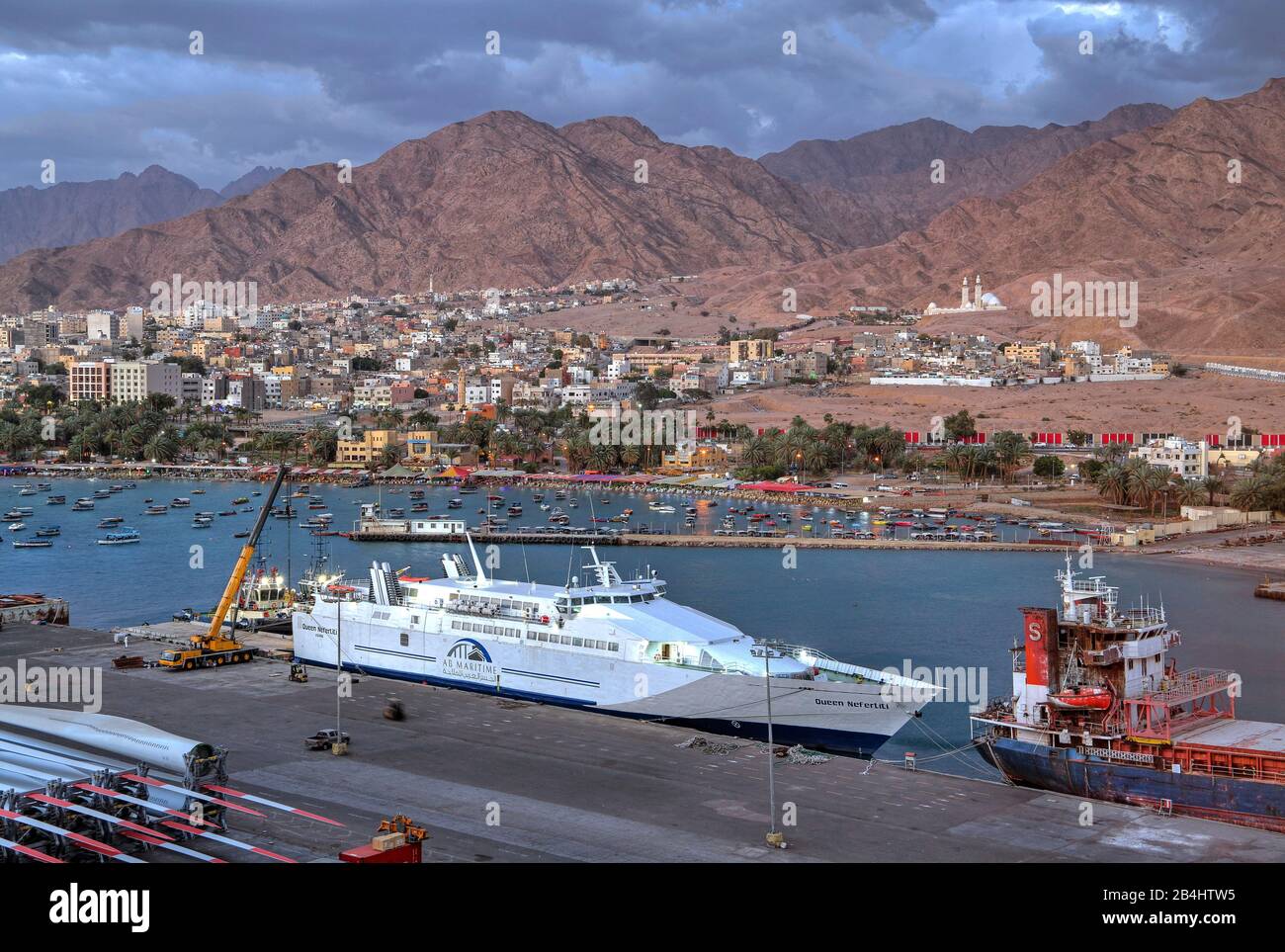Traghetto nel porto contro la città con acqua di fronte e montagne, Aqaba Aqaba, Golfo di Aqaba, Mar Rosso, Giordania Foto Stock