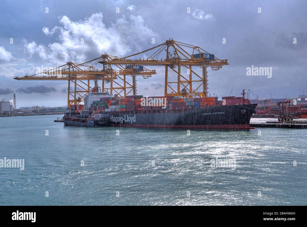 Nave con container nel porto durante la pioggia a Barcellona, Catalogna, Spagna Foto Stock