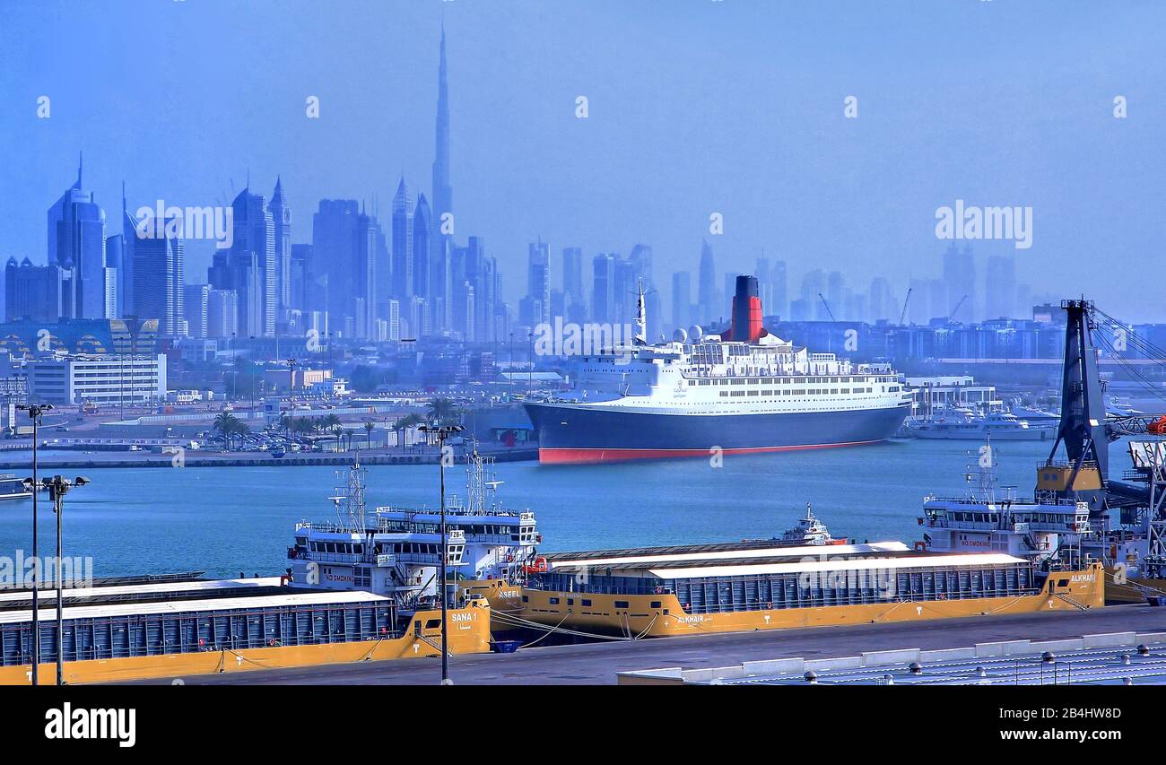 Hotel e museo nave Queen Elizabeth 2 (QE2) nel porto con skyline della città e Burj Khalifa 828m, Dubai, Golfo Persico, Emirati Arabi Uniti Foto Stock