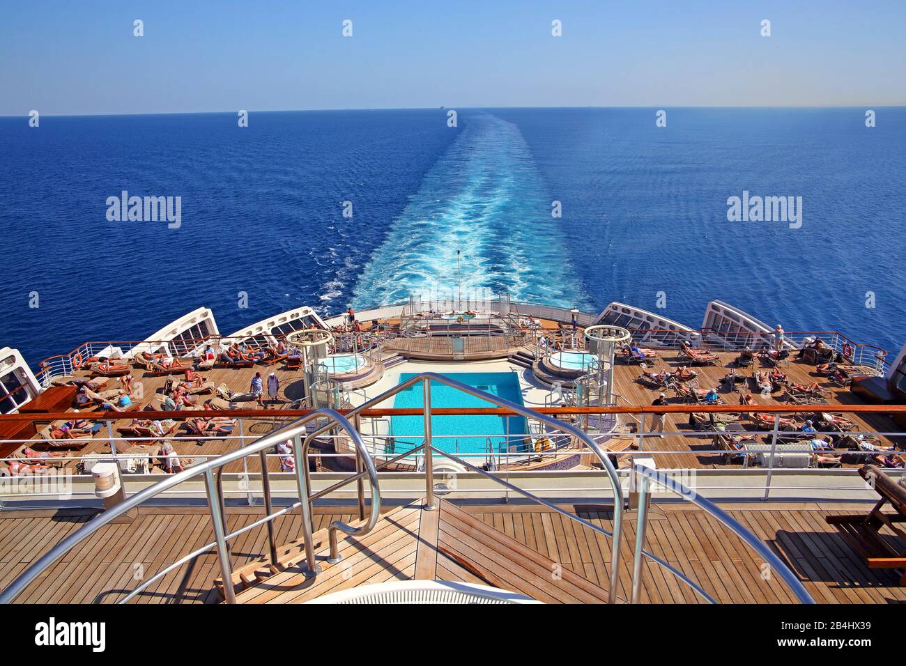 Terrazza sul retro con piscina e lettini sul transatlantico Queen Mary 2 Foto Stock