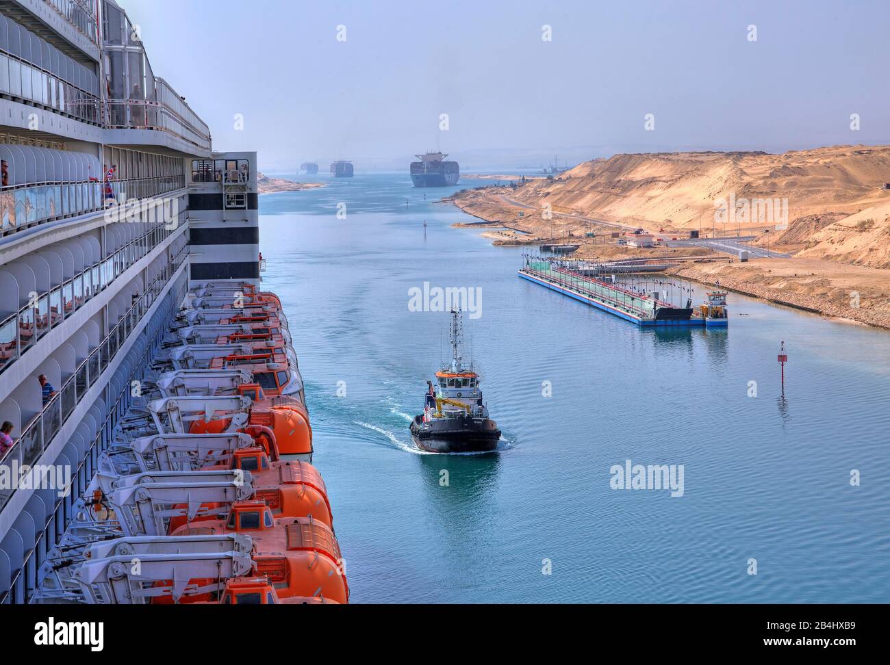 Vista laterale con ponte barca e balconi del transatlantico Liner Queen Mary 2 con convoglio nave nel canale di Suez (canale di Suez), Egitto Foto Stock