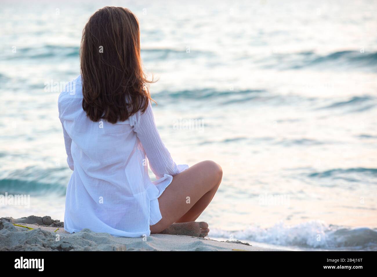 A gambe incrociate, da dietro, adolescenti, mare Foto Stock