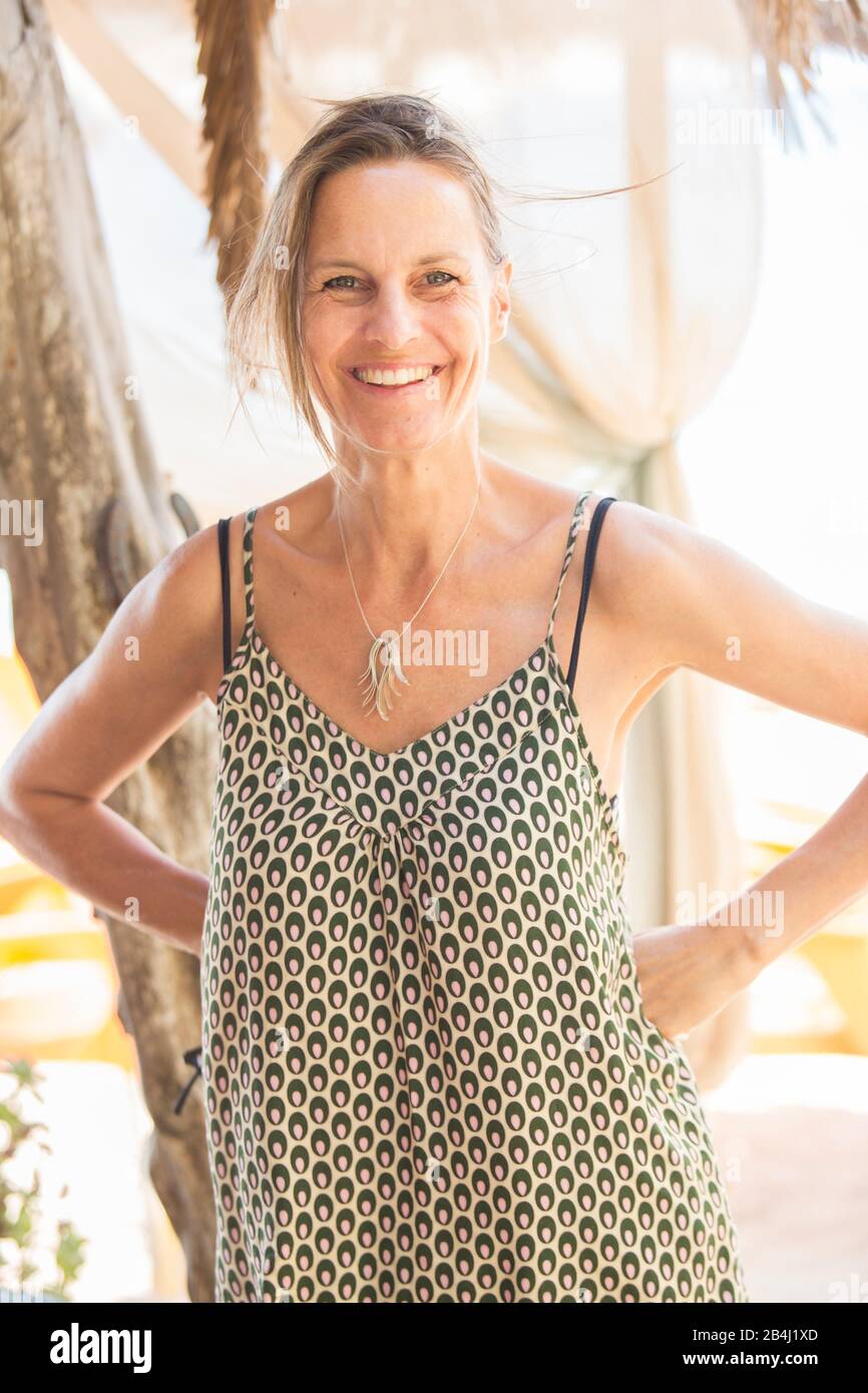 Donna, ridendo, le braccia appoggiate Foto Stock