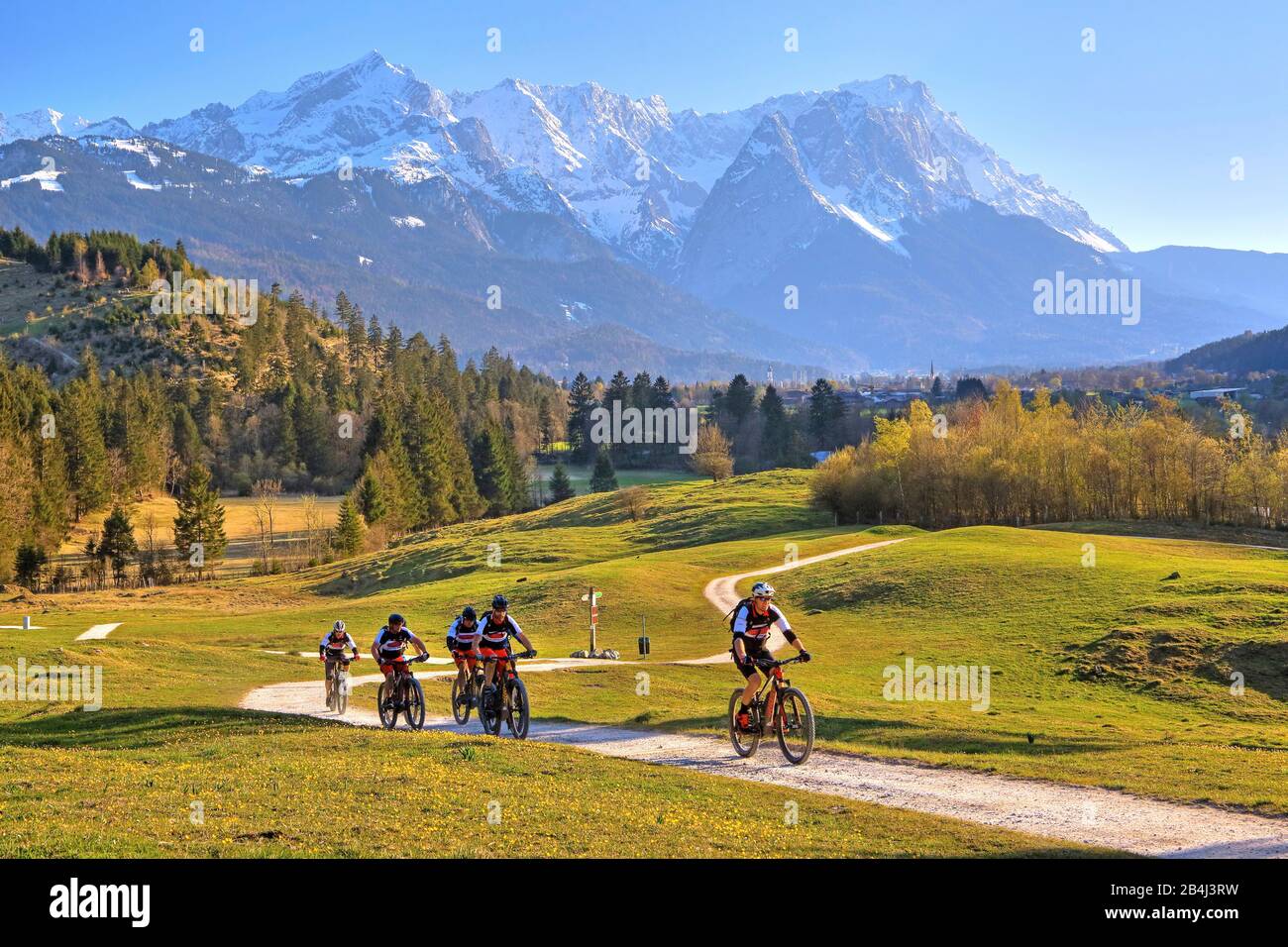 Ciclisti sulla Philosophenweg con Alpspitze 2628m Waxenstein 2277m e Zugspitze 2962m del Gruppo Zugspitze nelle montagne Wetterstein vicino Garmisch-Partenkirchen, Loisachtal, Werdenfelser Land, Zugspitzland, alta Baviera, Germania Foto Stock