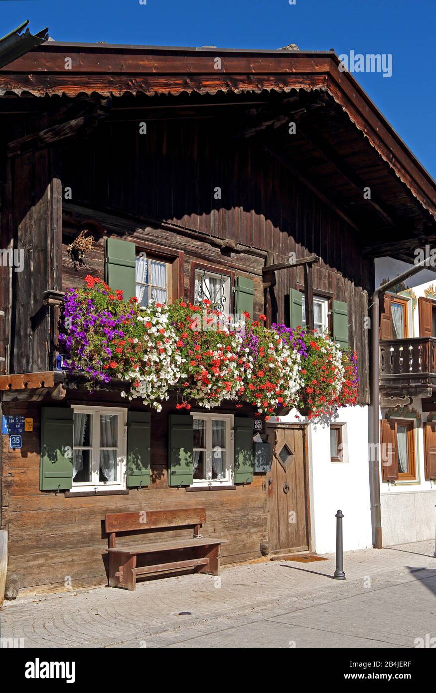 Tradizionale casa di campagna bavarese superiore con balcone di fiori, Garmisch-Partenkirchen, Werdenfelser Land, alta Baviera. Bayern Germania Foto Stock