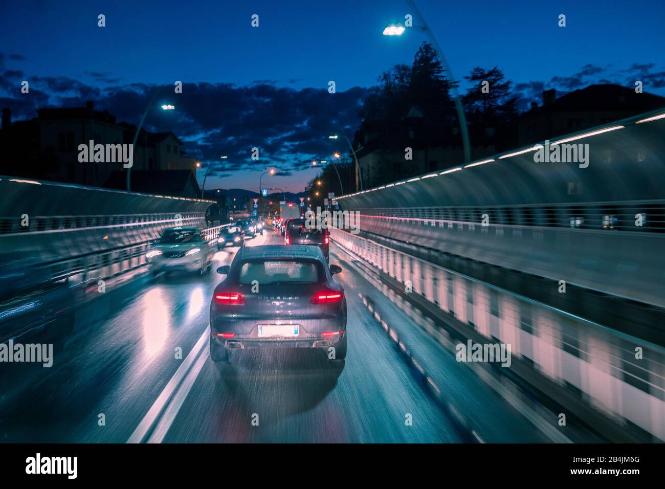 traffico serale di auto in città, ponte alpini, belluno, veneto, italia Foto Stock