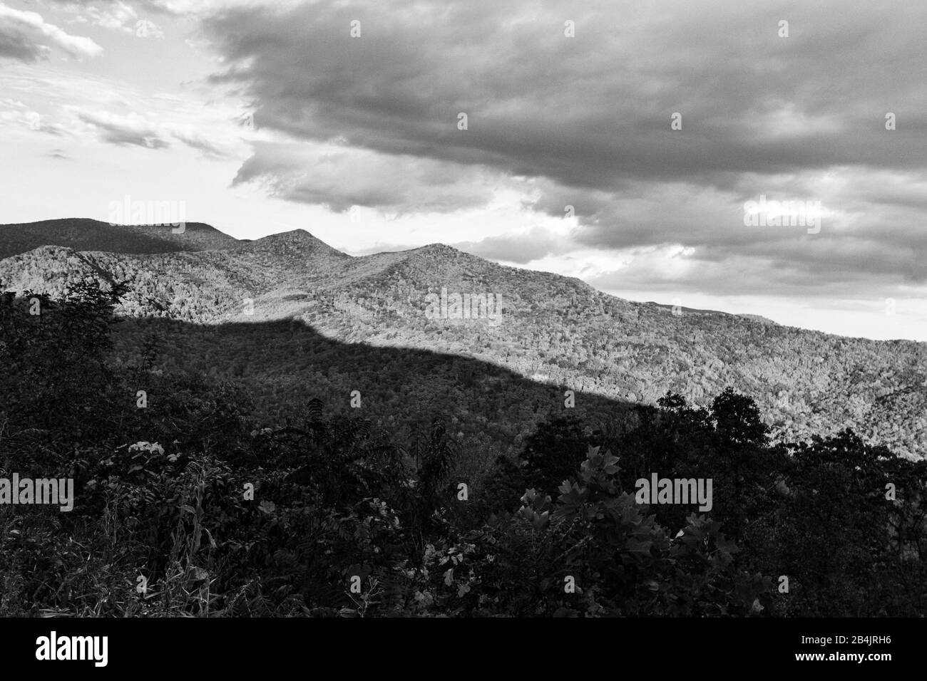 L'ombra dalla montagna dietro getta metà della montagna nell'oscurità, a Tanbark Ridge sovrasta ad Asheville, NC, Stati Uniti Foto Stock