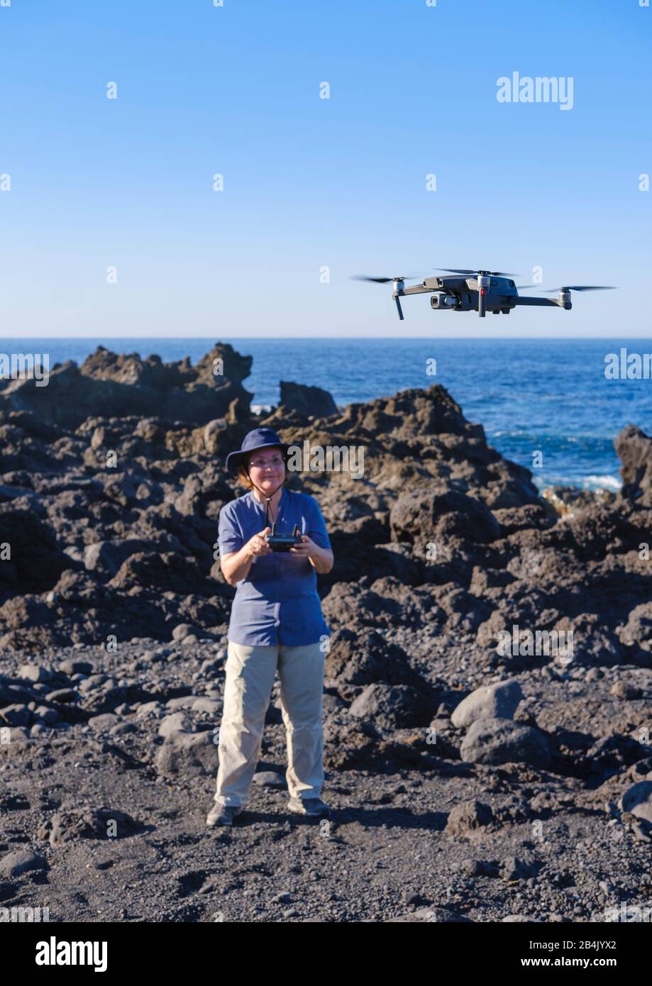 Donna controlla il drone in volo, Quadrocopter, Lanzarote, Isole Canarie, Spagna Foto Stock