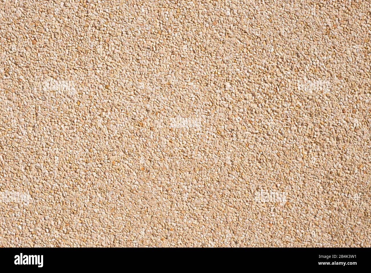 muro di stucco con piccole pietre in toni beige Foto Stock