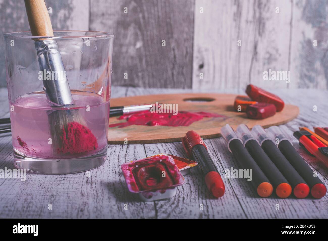 Disposizione di varie penne e utensili da pittura nel colore rosso Foto Stock