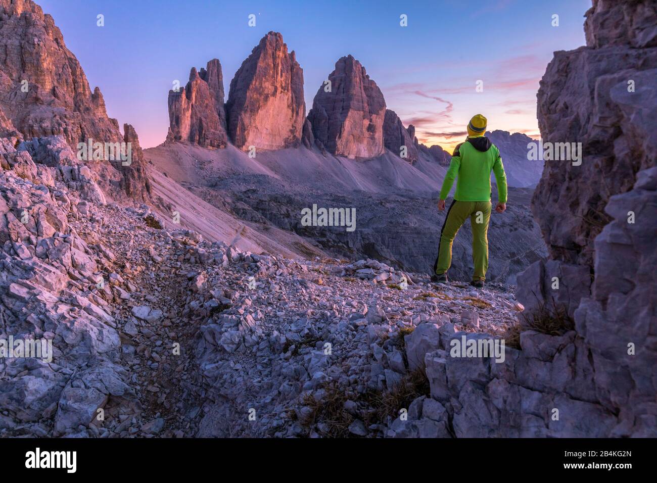 L'uomo in piedi ammira le tre cime di lavaredo al tramonto, Bolzano, Alto Adige, Italia, Europa Foto Stock