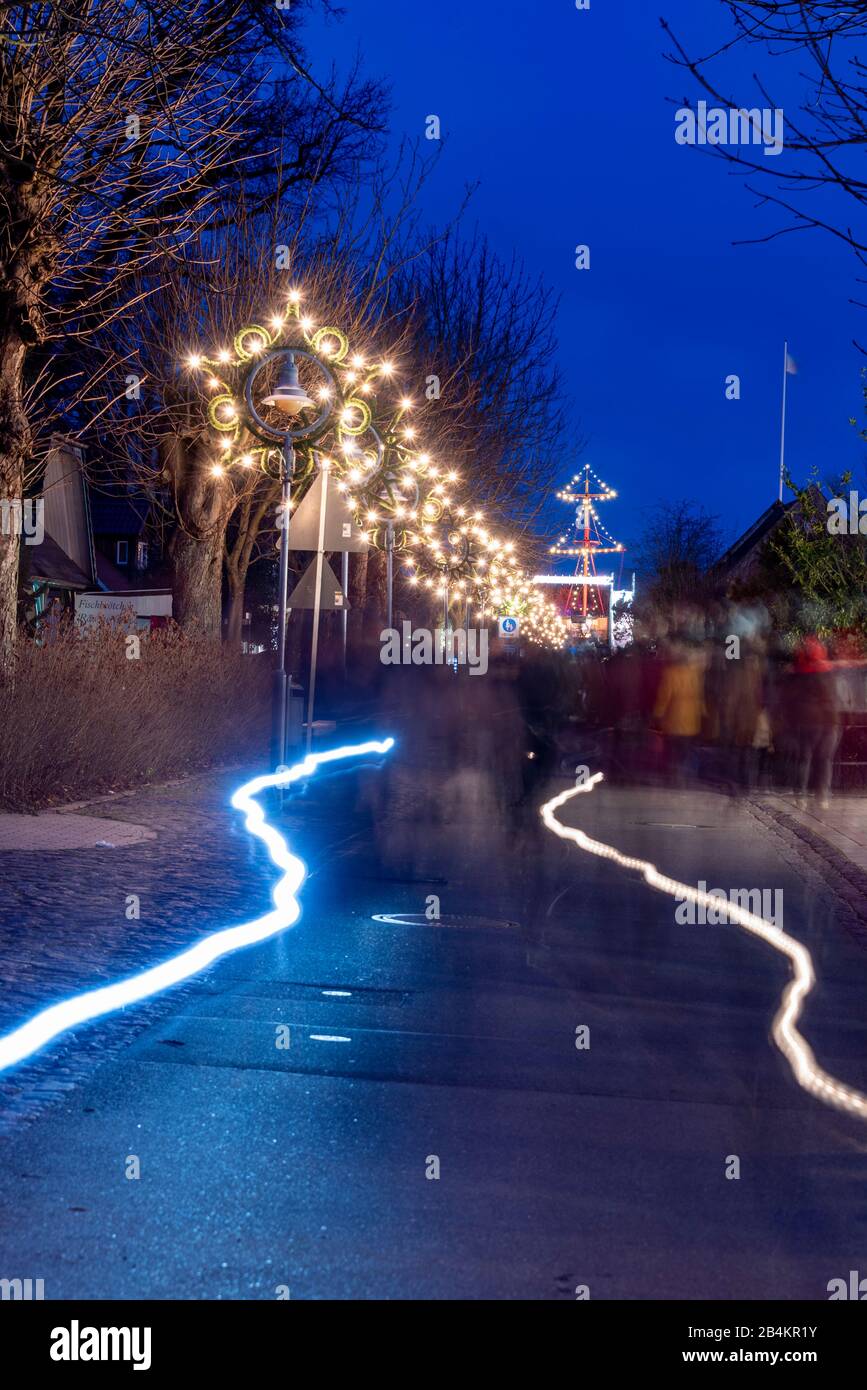 Germania, Meclemburgo-Pomerania anteriore, Zingst, Strandstrasse, poinsettias illuminata, sentiero per il mercato invernale Foto Stock