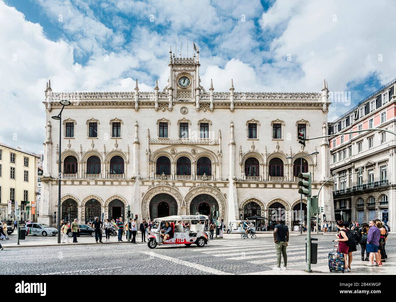 Europa, Portogallo, capitale, centro storico di Lisbona, Baixa, stazione Rossio stazione, Estacao do Rossio, EstaçÃ£o de Caminhos de ferro do Rossio, stile manuelina, vista esterna con tuk tuk e persone a piedi Foto Stock