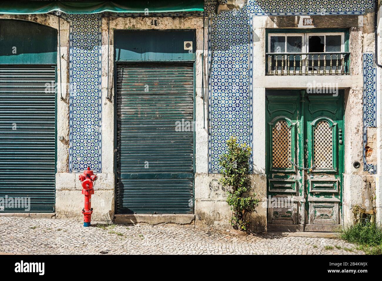 Europa, Portogallo, capitale, centro storico di Lisbona, Alfama, vecchia casa facciata con azulejos, porte in legno, tapparelle, idrante rosso Foto Stock