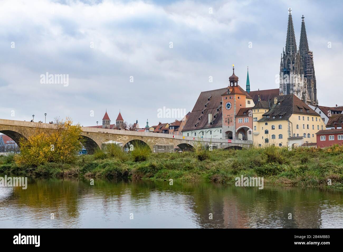 Germania, Baviera, Ratisbona, vista da jahninsel al Danubio, Steinerne Brücke e la città vecchia con il centro visitatori del Patrimonio Mondiale e la cattedrale in autunno Foto Stock