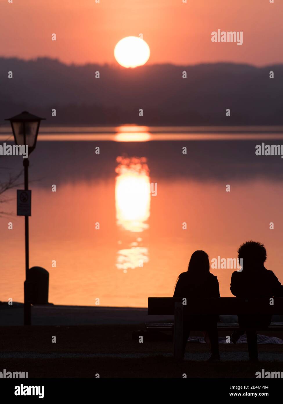 Estate in Baviera. Impressioni dai piedi delle Alpi: Sagome di due persone al lago Staffelsee al tramonto Foto Stock