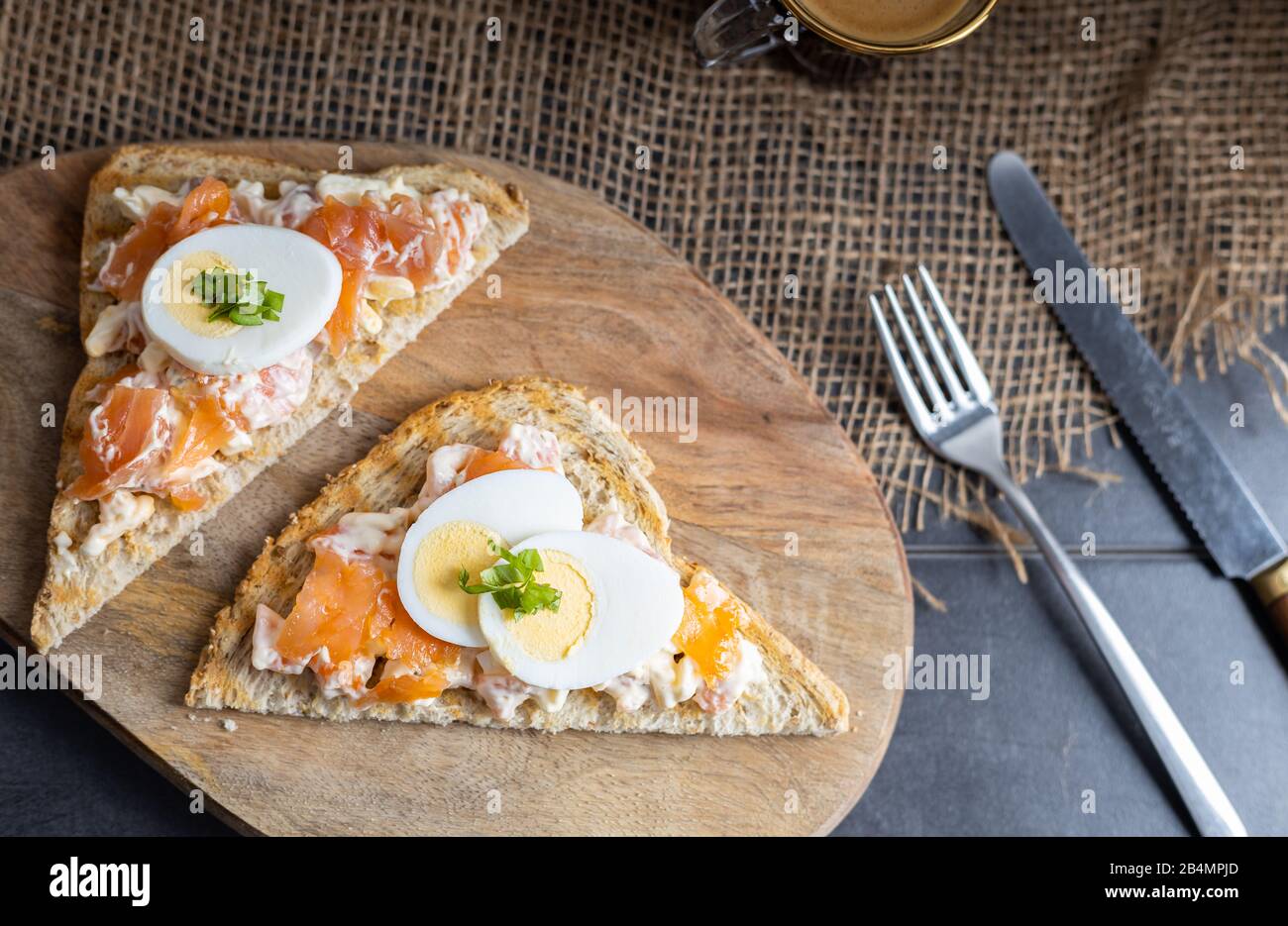 Una deliziosa diffusione di salmone affumicato fatta di yogurt e spezie su un pane tostato integrale con una tazza di caffè sul lato. Foto Stock