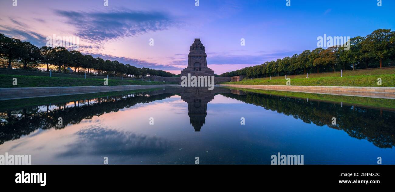 Germania, Sassonia, Lipsia, Völkerschlachtdenkmal all'alba, perfetta riflessione nel bacino idrico Foto Stock