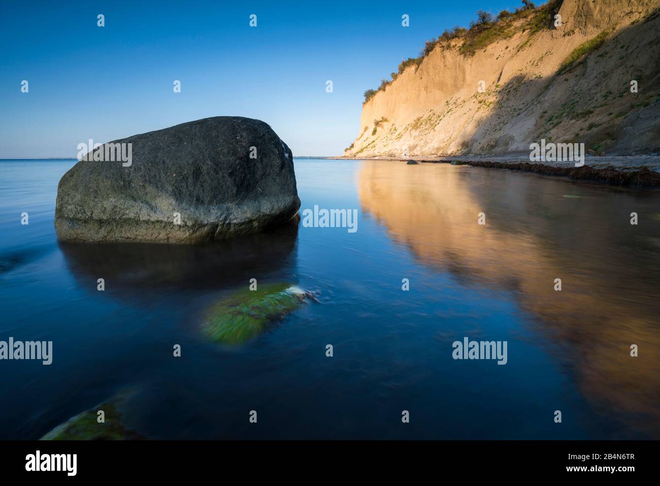 Mar Baltico in serata luce, lunga esposizione, spiaggia con pietre che vengono lavate dall'acqua, Foto Stock