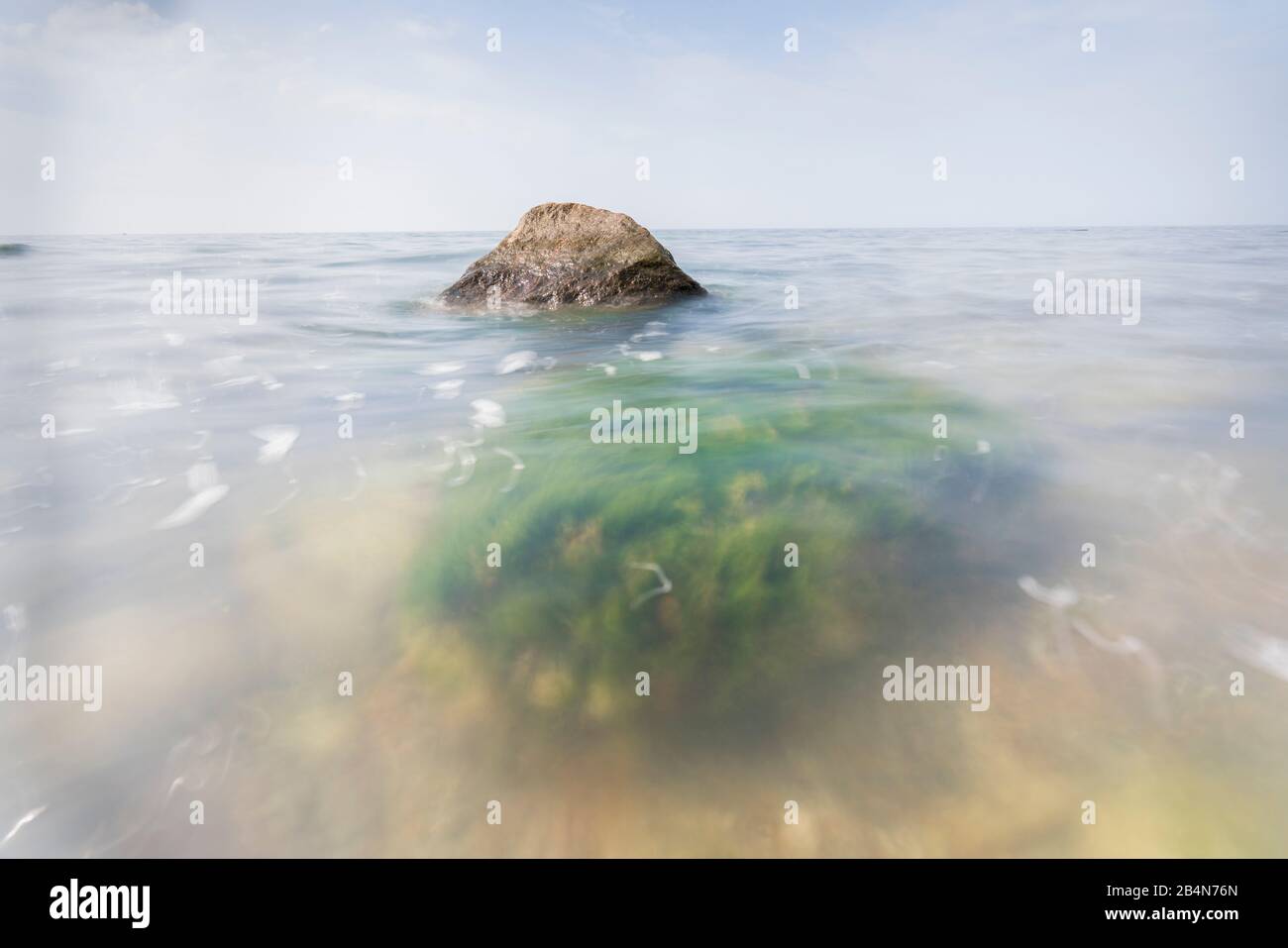 Mar Baltico in serata luce, lunga esposizione, spiaggia con pietre e alghe che vengono lavate dall'acqua, Foto Stock