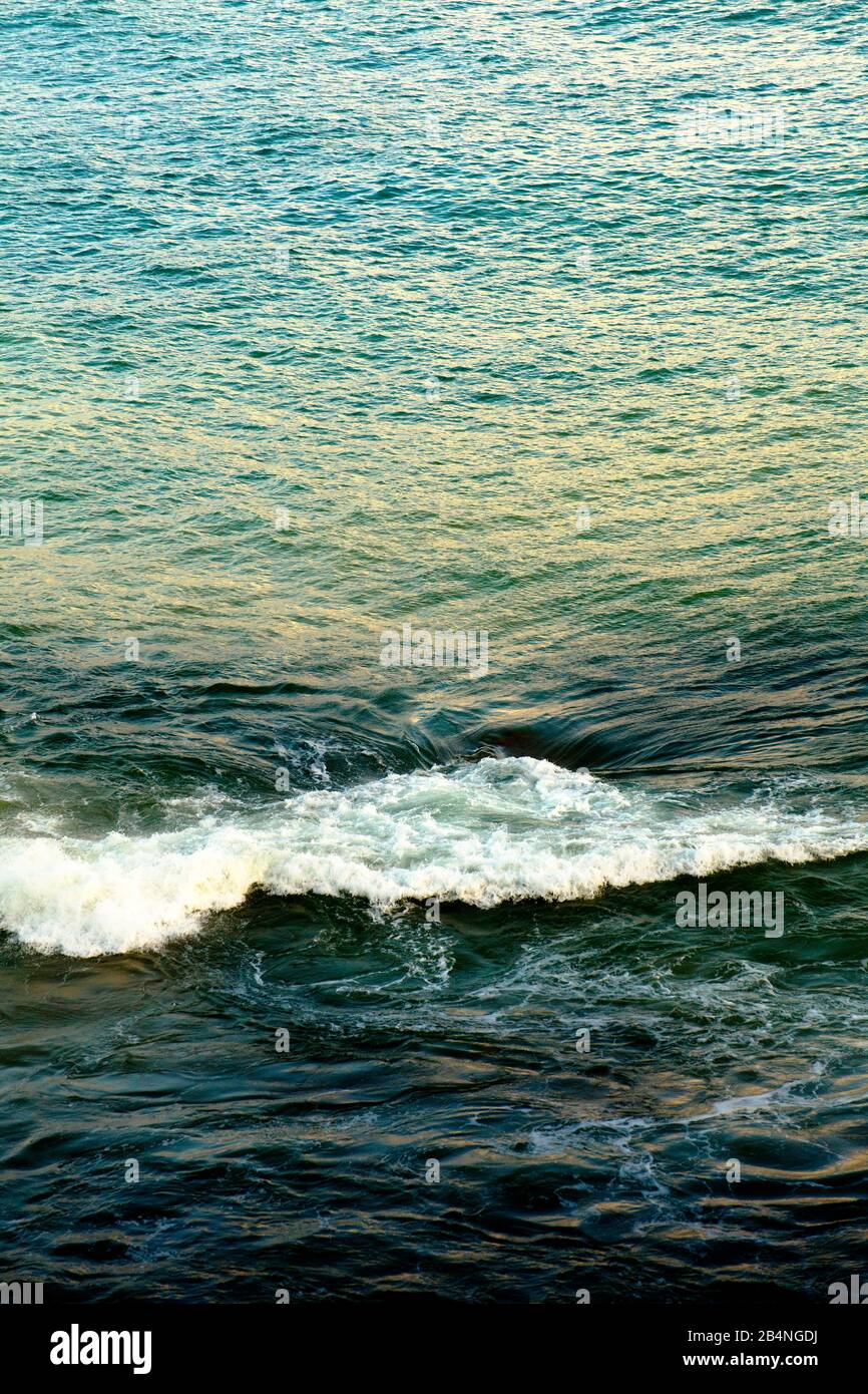 Con la marea, un pericoloso vortice d'acqua si forma tra scogliere nascoste. Foto Stock