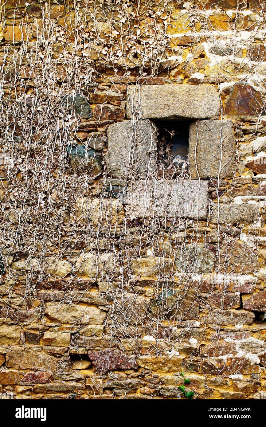 Piccolo portello della finestra in un muro rustico di pietra. Runan è un comune della Bretagna di Côtes-d'Armor con 233 abitanti. Foto Stock