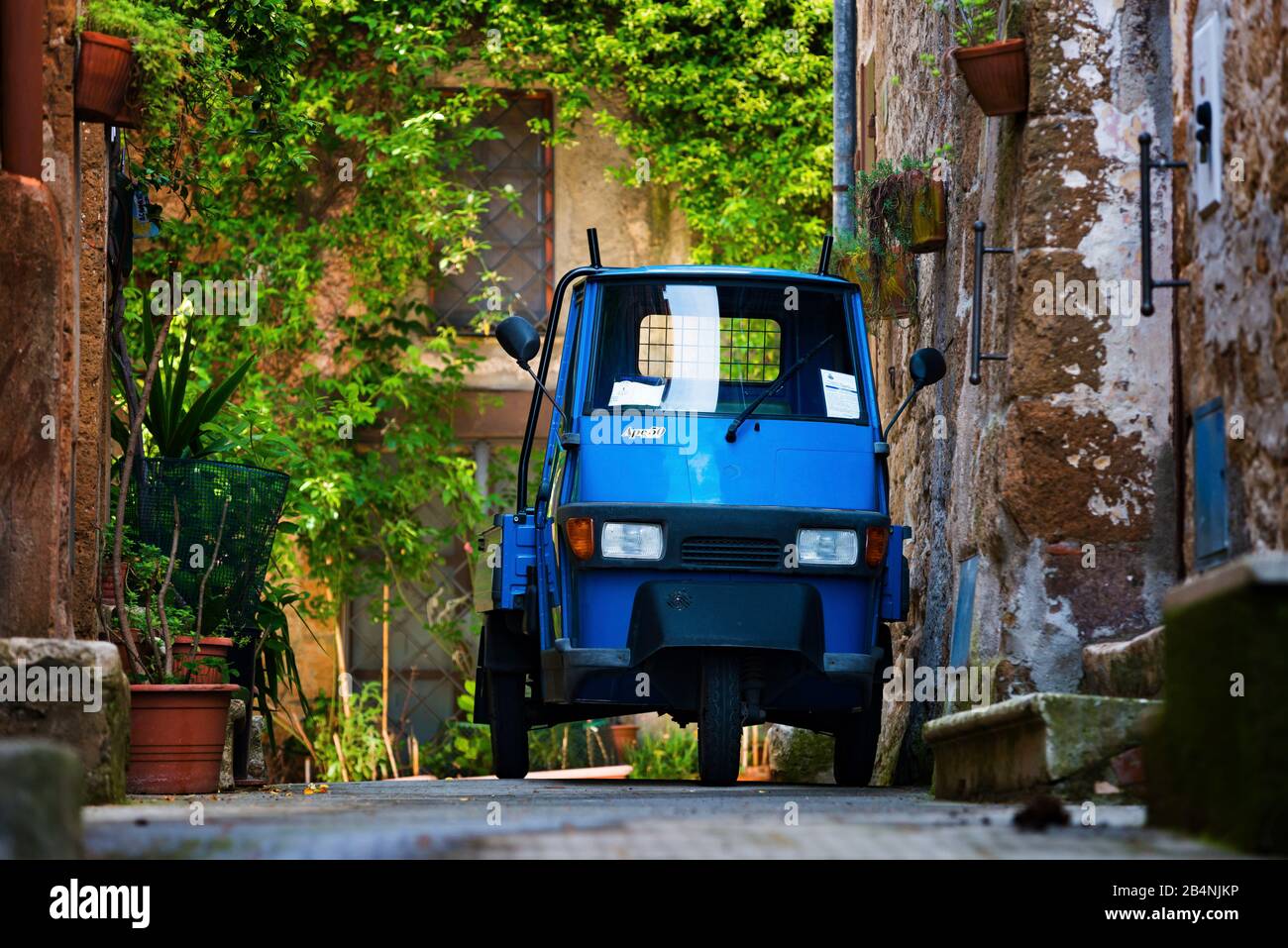 Piccolo ciclomotore blu in un vicolo a Pitigliano, Toscana, Italia Foto Stock