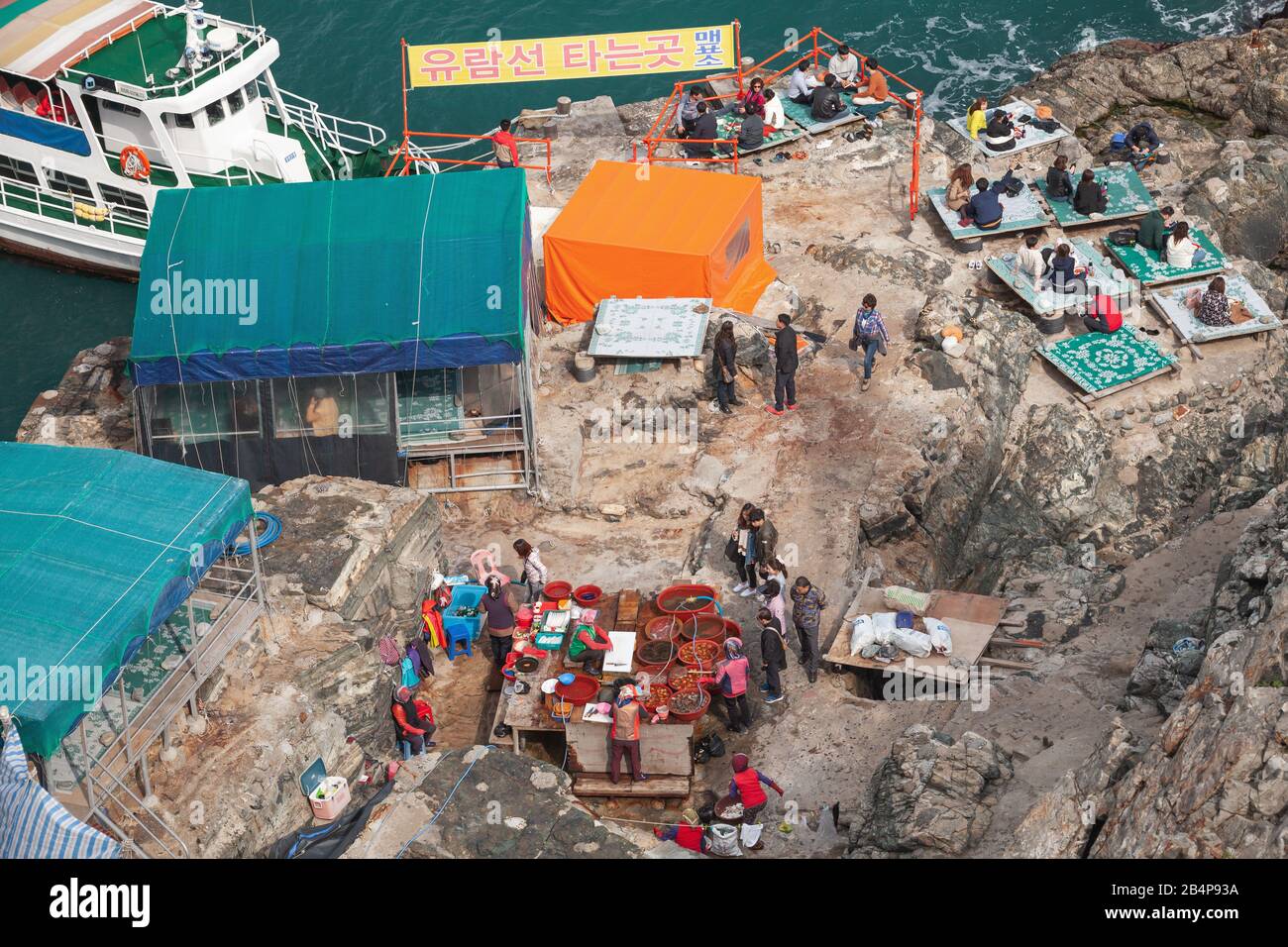 Busan, Corea del Sud - 18 marzo 2018: Le persone si trovano nel ristorante costiero di pesce all'aperto Haenyeochon sulle rocce costiere del parco naturale Taejongdae Foto Stock