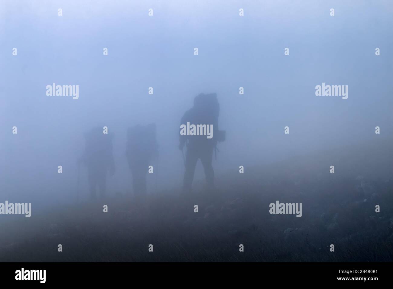 Un gruppo di turisti di montagna sorge a passare lungo il percorso, escursione in montagna. Le nubi sono prossimi Foto Stock