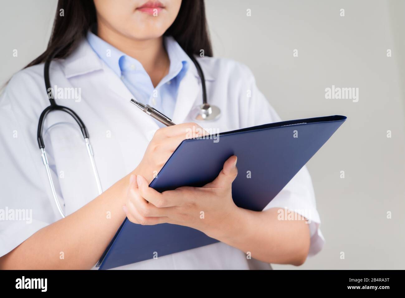 medico femminile che scrive informazioni mediche in un notebook in ospedale Foto Stock