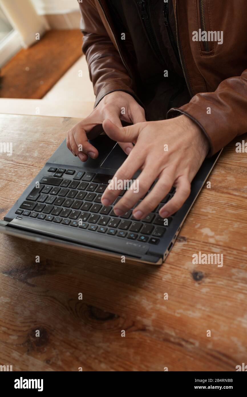 Un uomo la digitazione sul suo computer portatile Foto Stock