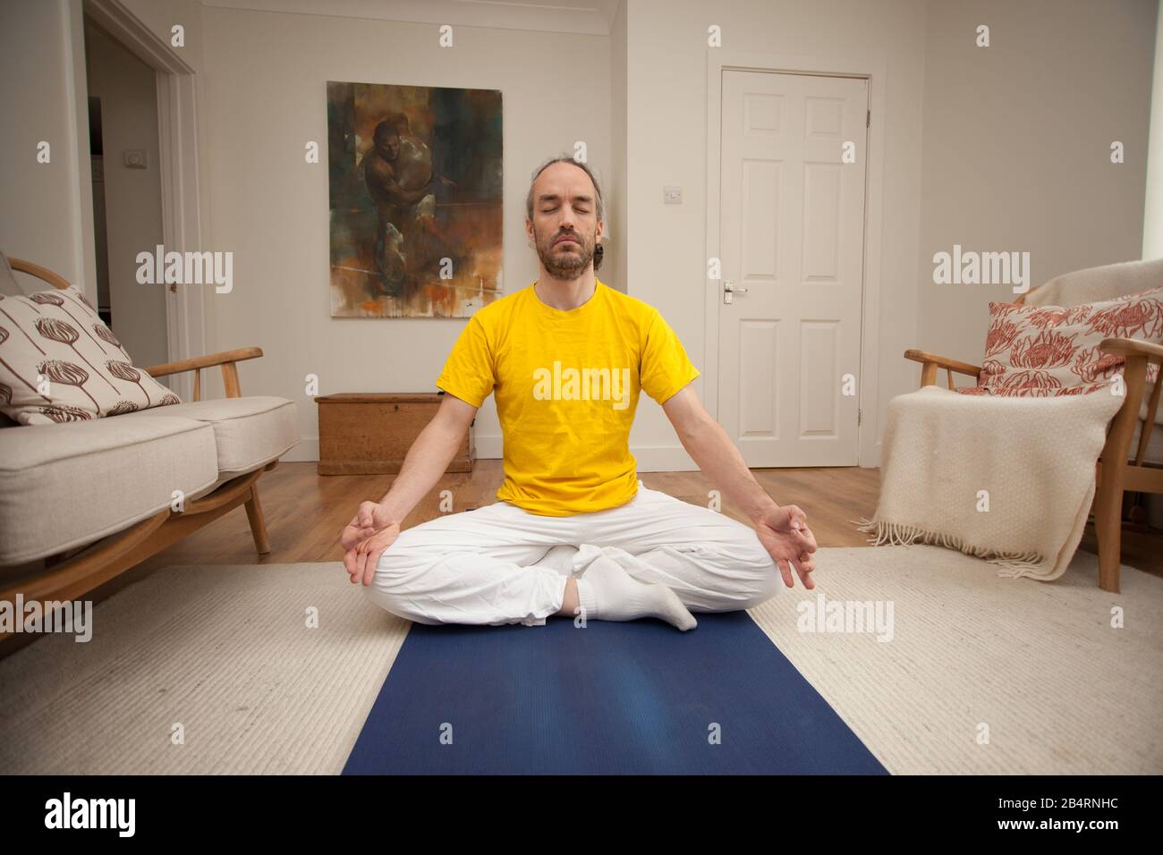 Un uomo che medita come parte della sua routine di Yoga Foto Stock