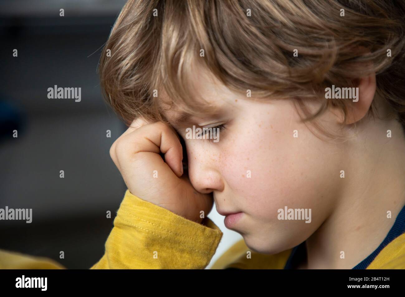 Bambino con mal di testa, ragazzo di 9 anni, con dolore viso distorto, immagine simbolica, Foto Stock