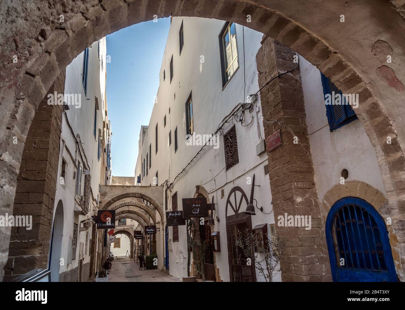 Archi e negozi presso il vicolo di Medina lungo i merli di Essaouira. La città è stata dichiarata Patrimonio dell'Umanità dall'UNESCO. Foto Stock