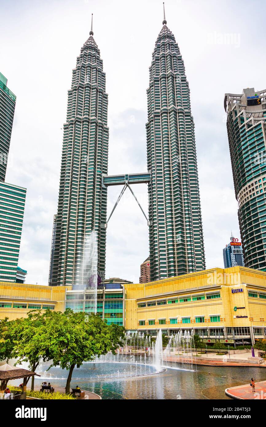 Petronas torri con un centro commerciale sotto e il parco pubblico KLCC con fontane, Kuala Lumpur, Malesia, Asia Foto Stock