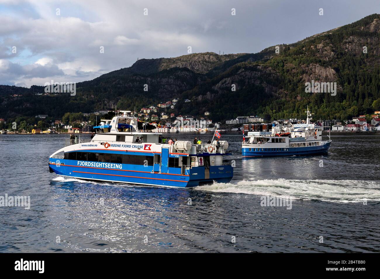 Catamarano ad alta velocità Rygertroll con partenza dal porto di Bergen, Norvegia. Crociera e charter nave Lykkeper in background Foto Stock