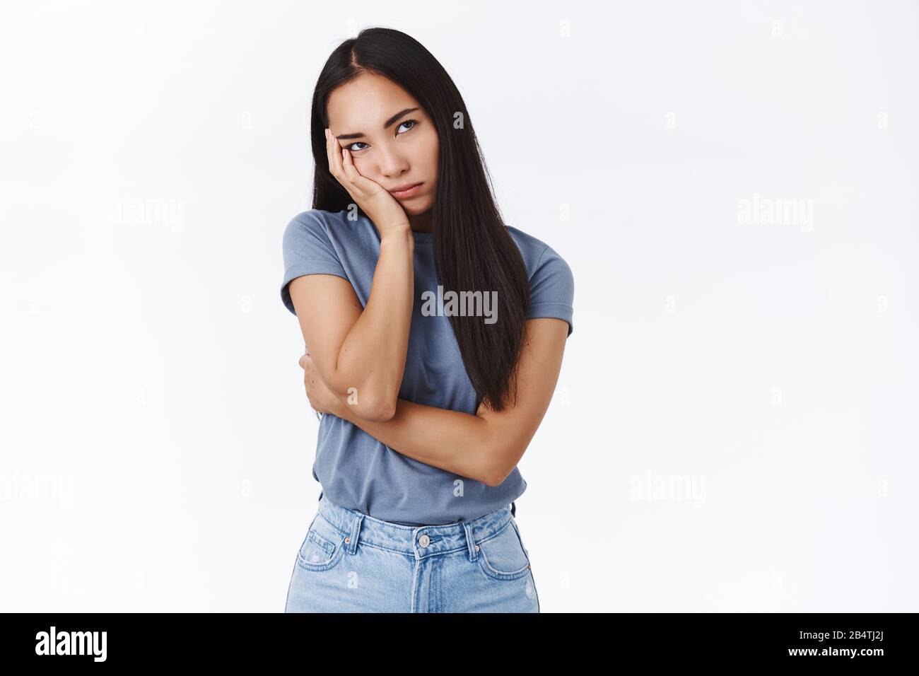 Infastidito e annoiato studentessa asiatica essendo a terra, gli occhi rotolanti dal fastidio e dalla seccatura, magra sul palmo, immolante dispiaciuto e infelice, gemendo Foto Stock