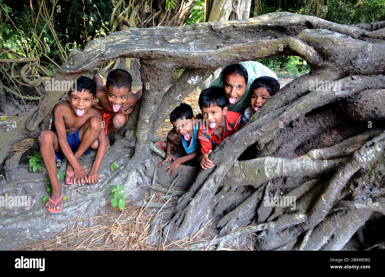 Tempo di divertimento - i bambini remoti del villaggio stanno giocando con radice dell'albero. Foto Stock