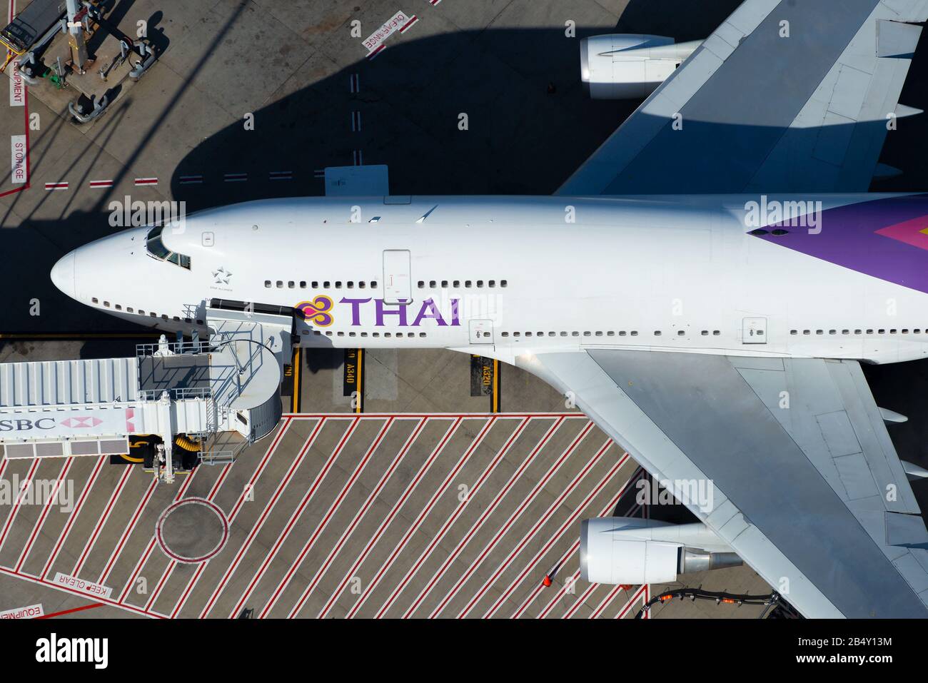 Thai Airways International Boeing 747 parcheggiata presso un cancello con ponte a getto per i passeggeri a bordo in un terminal aeroportuale. Boeing 747-400 HS-TGY. Foto Stock