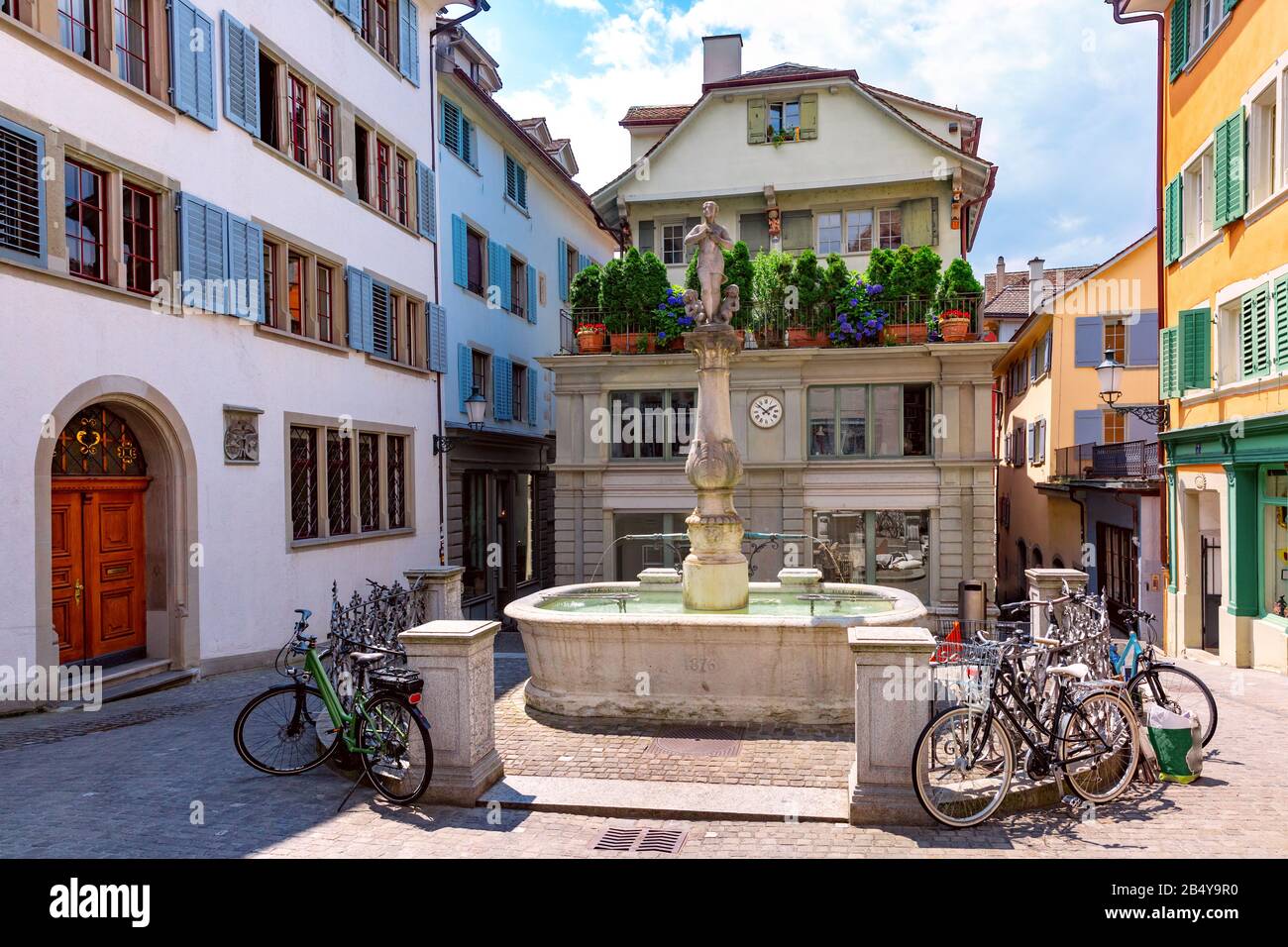 Bella piccola piazza con ciotola fontaine Napfbrunnen nella città vecchia di Zurigo in giornata di sole, Svizzera Foto Stock
