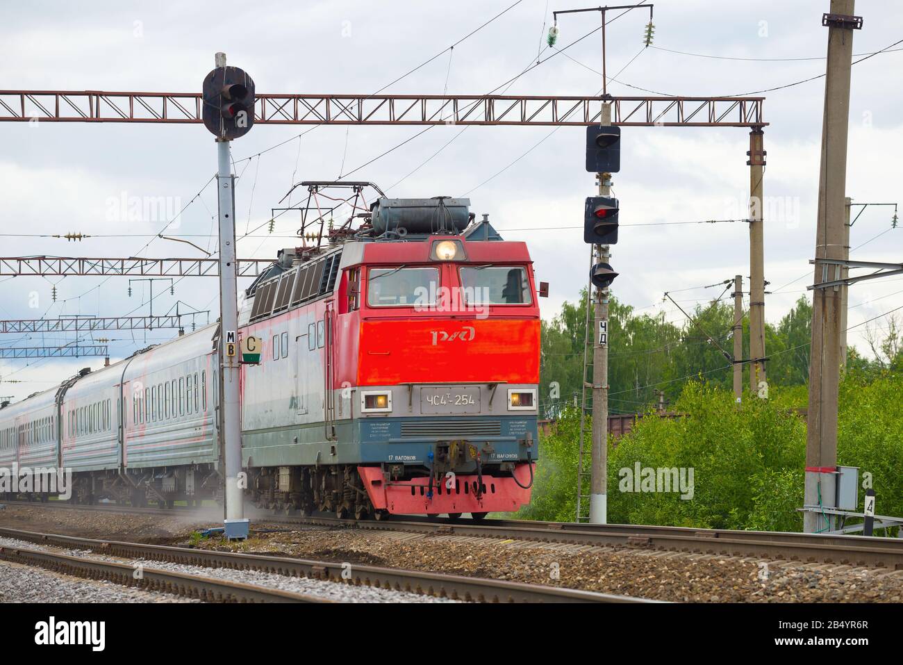Regione KOSTROM, RUSSIA - 29 GIUGNO 2019: Locomotiva elettrica ceca ChS4t con un treno passeggeri in movimento in una giornata torbida di giugno. Northern Railway Foto Stock