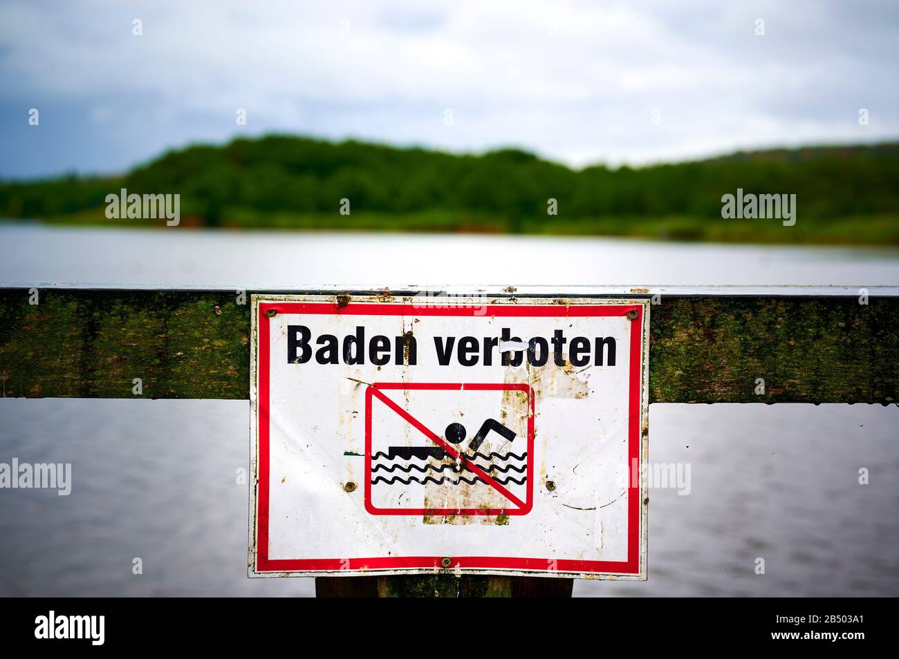 Segno con un pittogramma che proibisce il nuoto. Il testo significa fare il bagno vietato in tedesco. Foto Stock
